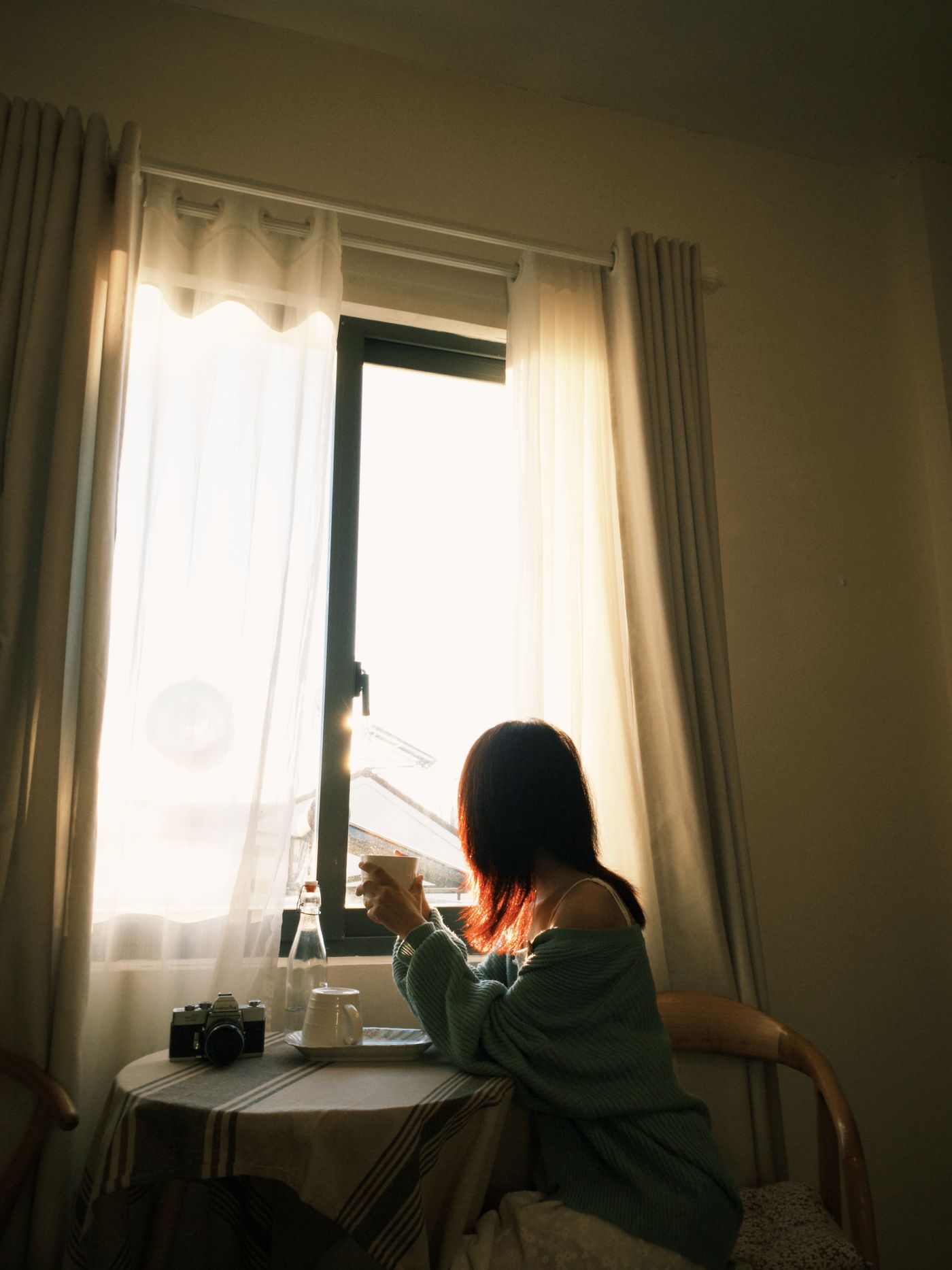 Someone sitting quietly by a sunlit window